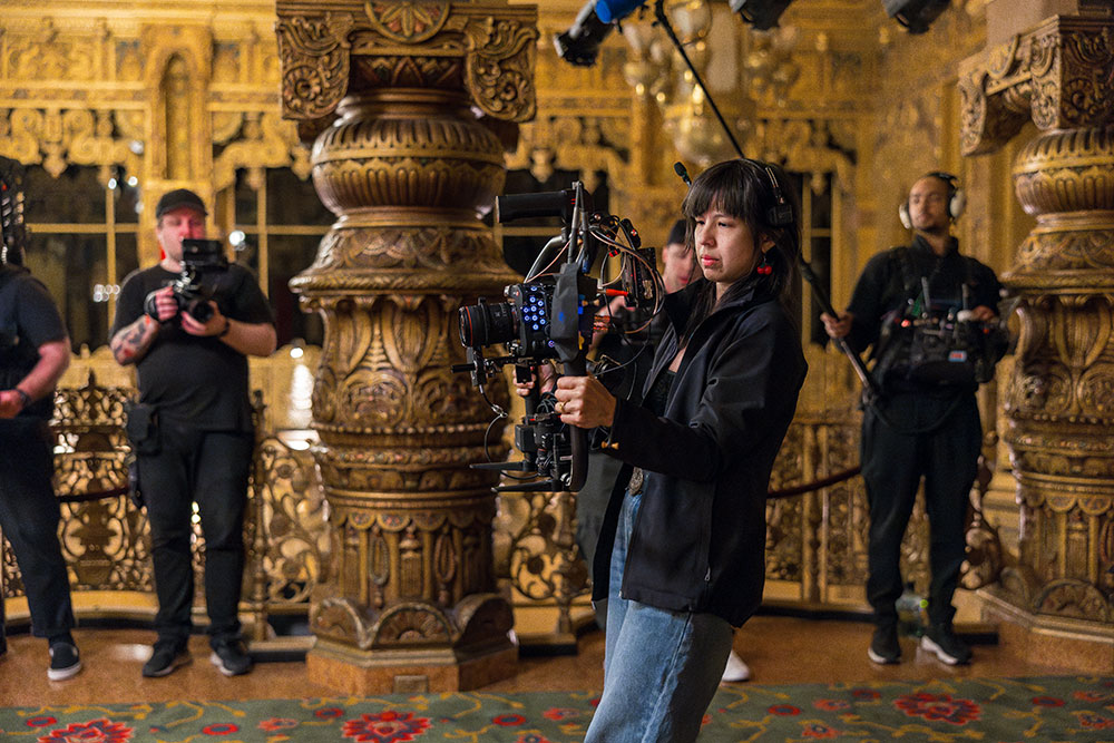 A woman staring into a camera rig with concentration, preparing for a video shoot
