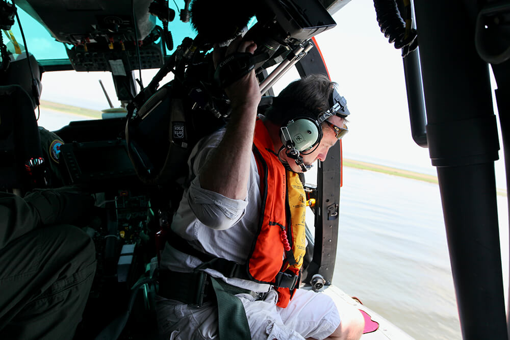 Image of Andy Taylor filming the Deep Water Horizon oil spill from a US Coast Guard Helicopter by Michael Usher