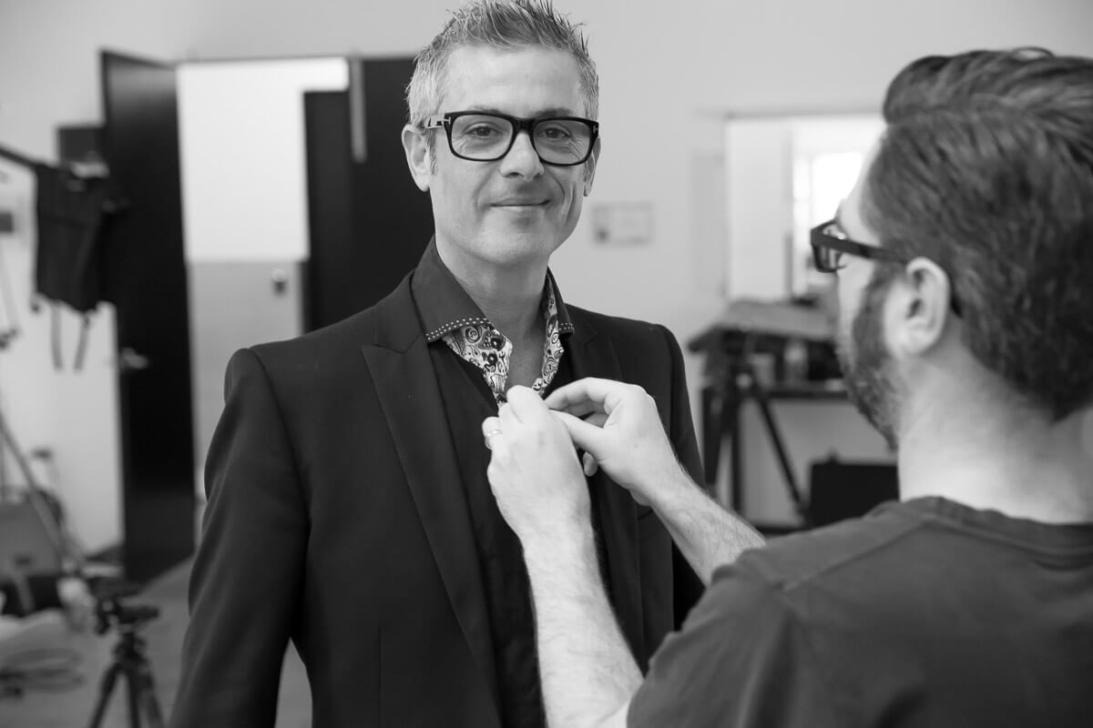 Black and white image of Daniel Linnet having shirt adjusted