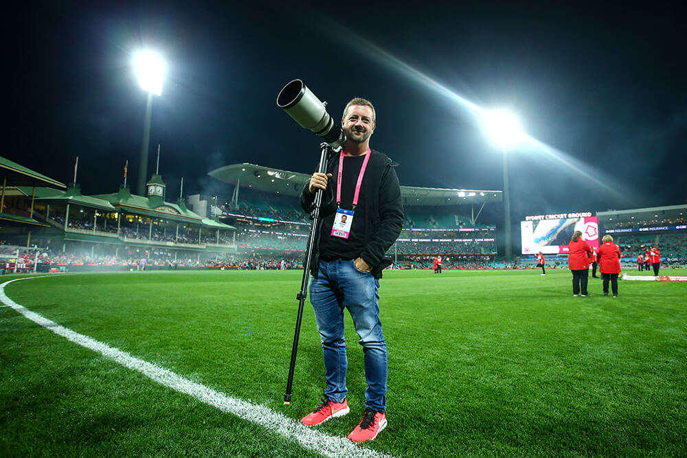 Image of Phil Hillyard holding a telephoto lens