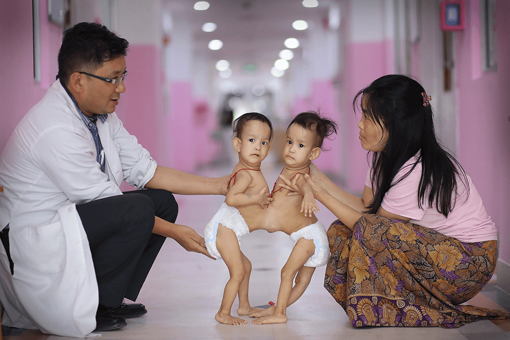 Conjoined 15-month-old twins Nima and Dawa with Paediatrician Dr Karma Sherub, and mum Bhumchu. Canon 1D X Mark II, EF85mm f/1.8 USM lens. 1/400s @ f1.8, ISO 2000.