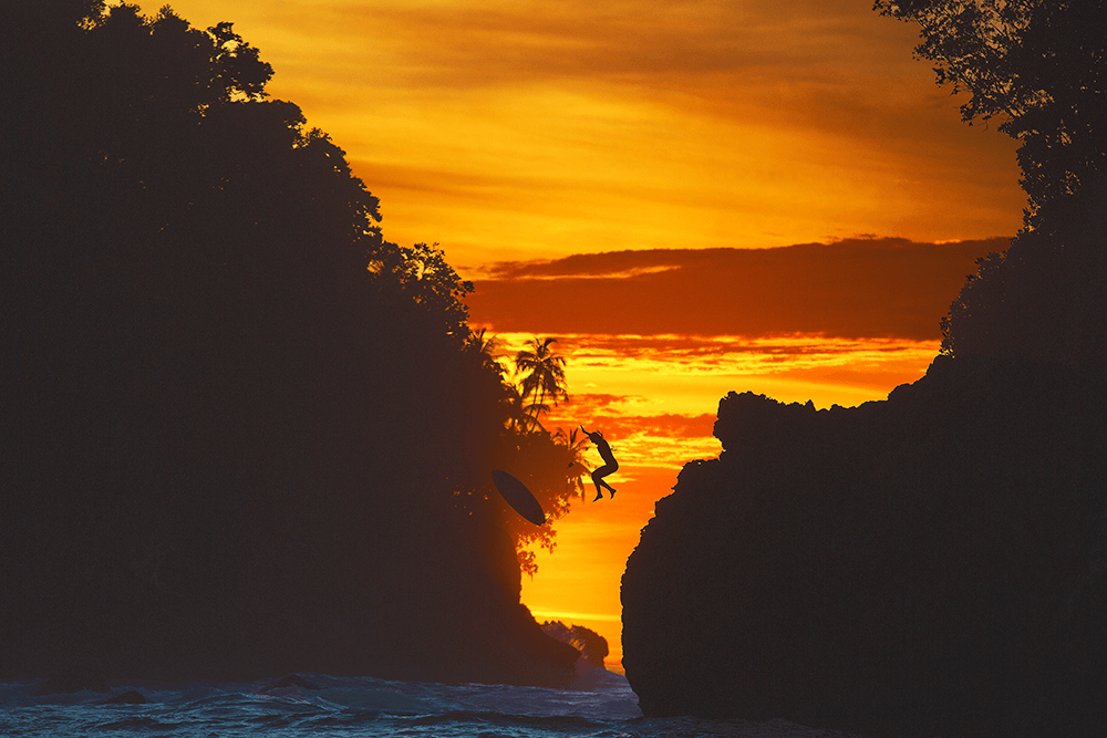 Raine scaled the rocks and jumped off at sunset in the Mentawai Islands, Indonesia. Taken by Matt Dunbar using a Canon 5D Mark III, EF70-200mm f/2.8L IS II USM lens @ 200mm.