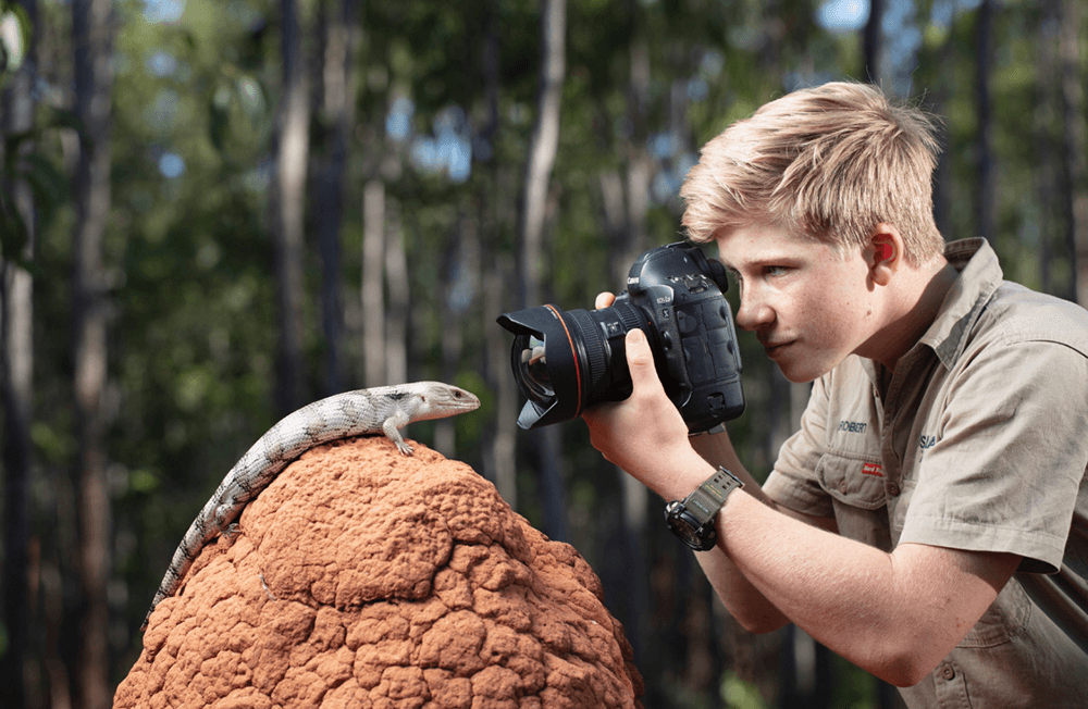 Robert Irwin taking a picture of a lizard