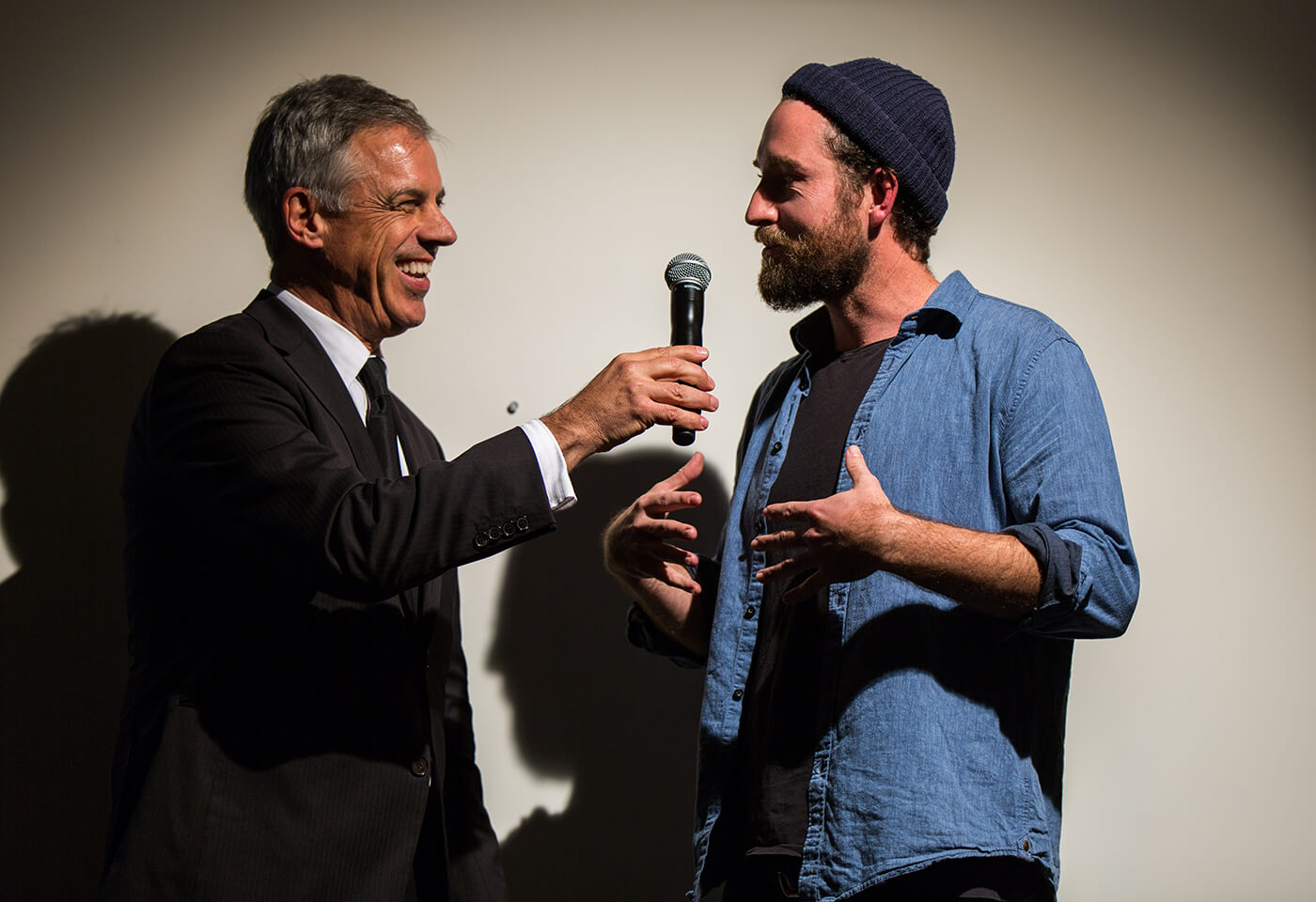 Gentleman in denim shirt being interviewed by man in suit