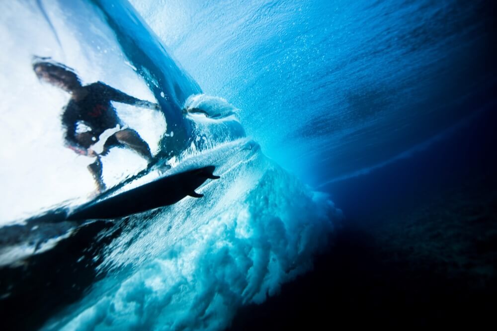 Person surfing on clear blue water