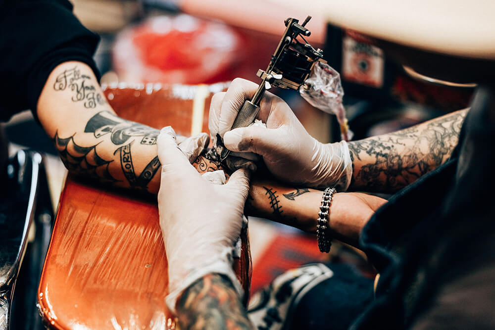 Image of a tattoo artist taken with the EOS R. Shot by Maria Boyadgis
