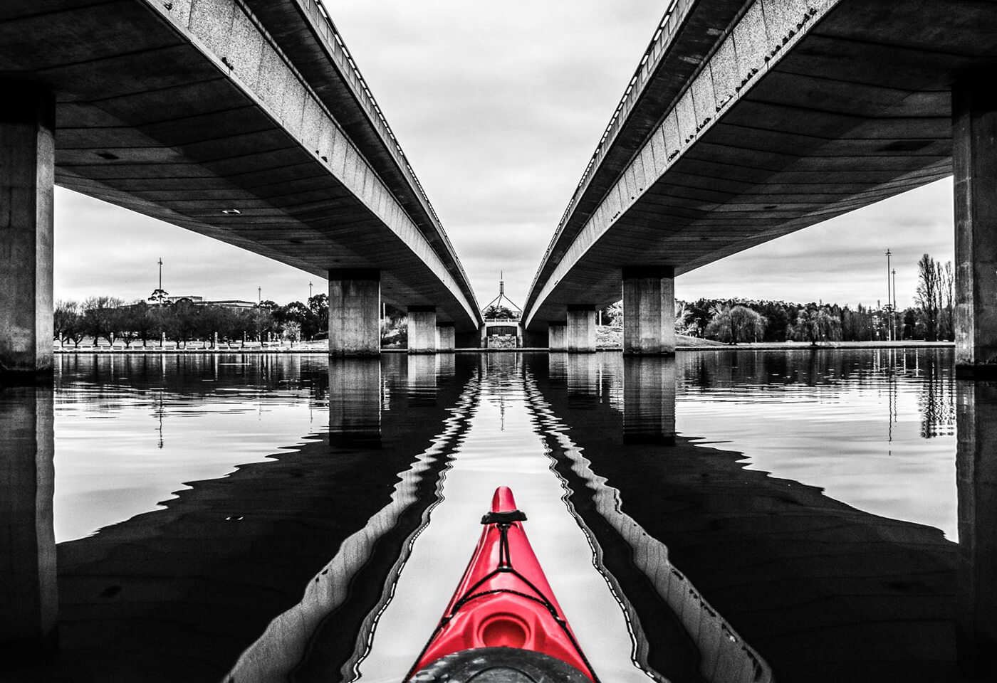 image of red kayak tip between two bridges