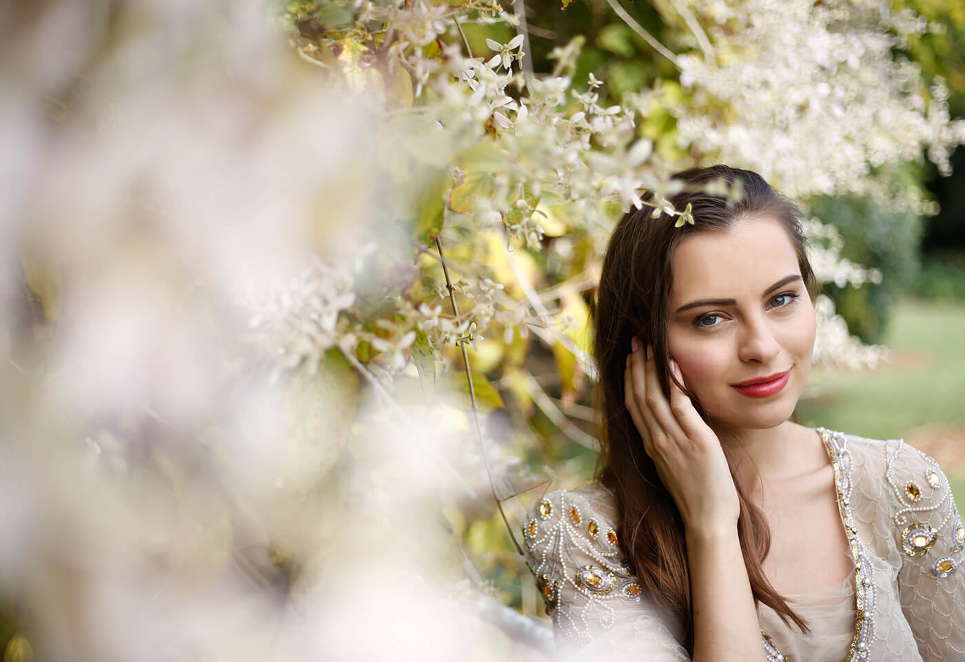 Young brunette lady among flowers taken using a Canon DSLR camera and prime lens